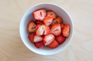 Beyaz bir kase içinde birkaç kesilerek çilek