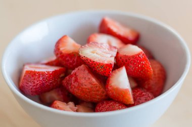 Beyaz bir kase içinde birkaç kesilerek çilek