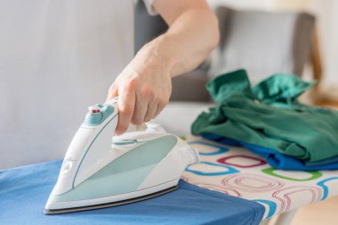 Mavi bir gömlek ile bir Ütü Masası üzerinde demir SID'sinin kapat