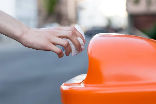 Tirar basura a un cubo de basura naranja en la calle — Foto de Stock
