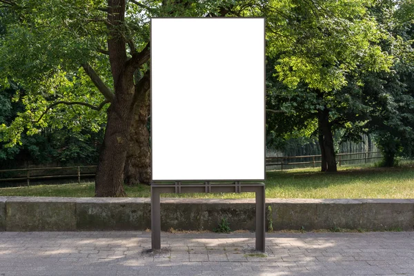 Blank ad space sign isolated in front of a park