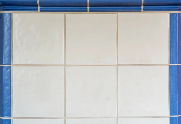 Bílé obklady z kachlových kamen, orámované s modré dlaždice — Stock fotografie