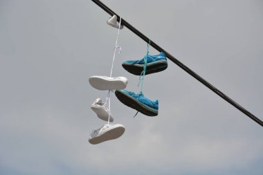 Two pairs of shoes hanging from a line clipart