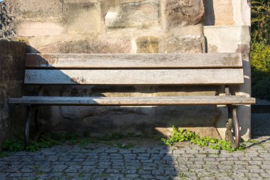 Taştan bir duvar önünde ahşap Bank