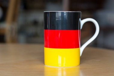 Alman bayrağı bir kupa üzerinde bulanık arka plan ile yakın çekim