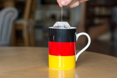 Bir çay poşeti bir kupa ile Alman bayrağı üzerinde bulanık b ile koyarak