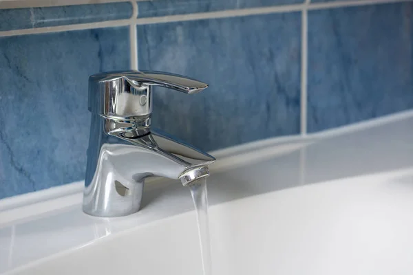 Voda tekoucí z kohoutku voda v koupelně — Stock fotografie