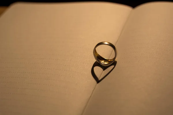 Bir yüzük hattı ile boş bir kitap üzerine gölge yapılmış bir kalp