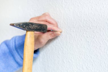 Beyaz bir duvar içine çivi çekiç