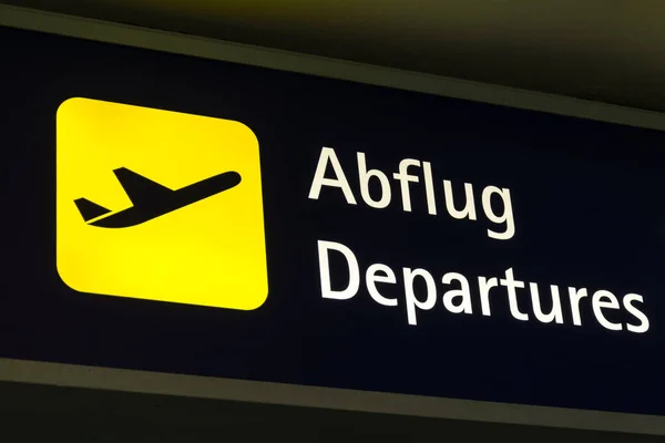 Yellow departures sign in German and English — Stock Photo, Image