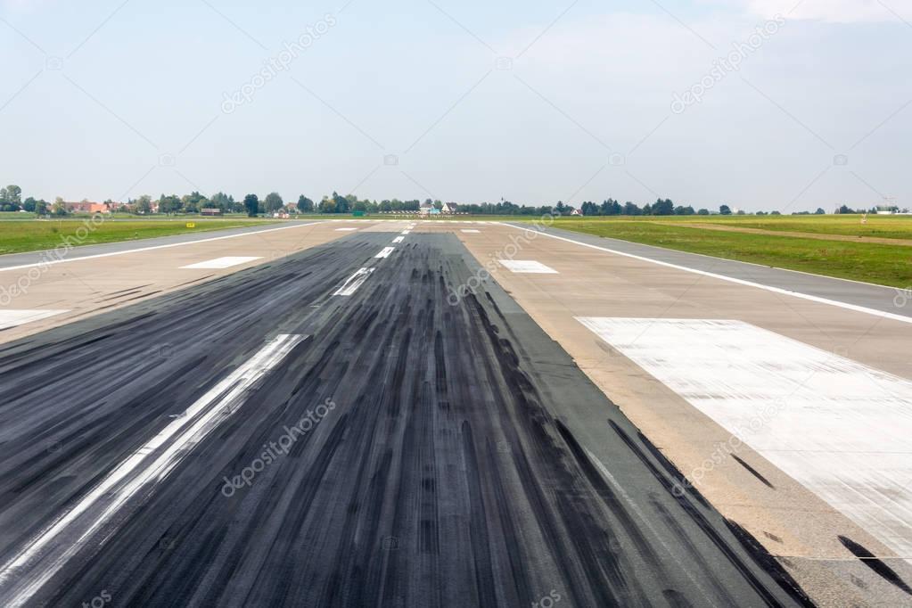Runway at an airport with grass to the side