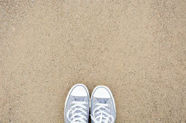 Yukarıdan kum üzerinde iki ayakkabı ile ayakta
