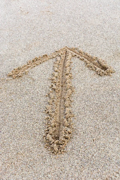 Pfeil von oben in den Sand gezogen — Stockfoto