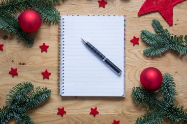 Yılbaşı süsleri ve köknar dallarında bir w ile boş not defteri