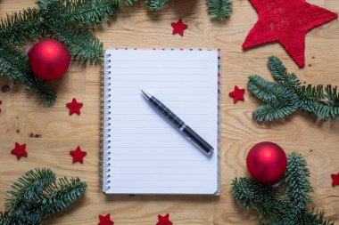 Yılbaşı süsleri ve köknar dallarında bir w ile boş not defteri