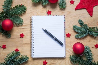 Yılbaşı süsleri ve köknar dallarında bir w ile boş not defteri