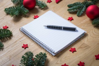 Yılbaşı süsleri ve köknar dallarında bir w ile boş not defteri