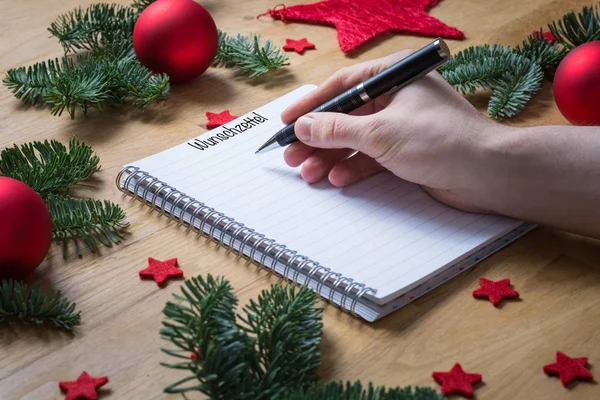 Writing a wish list for Christmas in German on a notepad with Ch — Stock Photo, Image