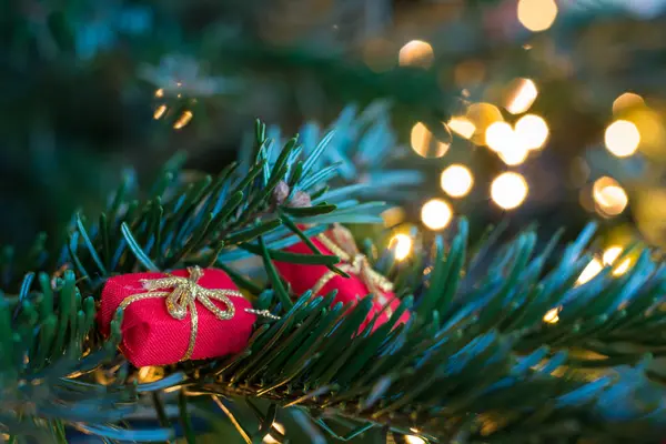 Pequenos ornamentos de presente vermelho em uma árvore de Natal — Fotografia de Stock