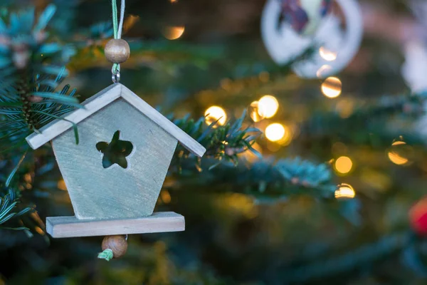 Dřevěný dům ozdoba visí na vánoční stromeček — Stock fotografie