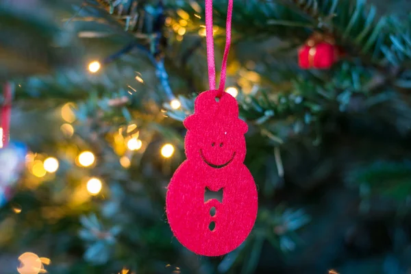 Kleiner roter Schneemannschmuck, der an einem Weihnachtsbaum hängt — Stockfoto