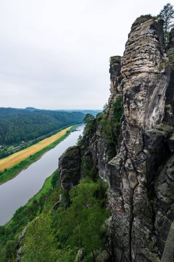 Bir kaya ve Elbe nehri Sakson İsviçre 'de Dresden yakınlarında bulutlu bir günde