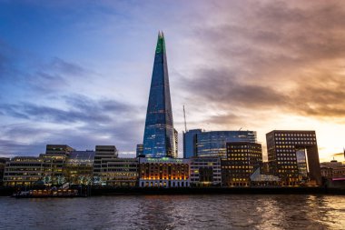 Çömlek ve diğer binalar gün batımında Thames nehrinde aydınlandı.
