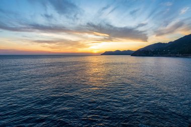 Günbatımında bulutlarla Cinque Terre 'de deniz manzarası