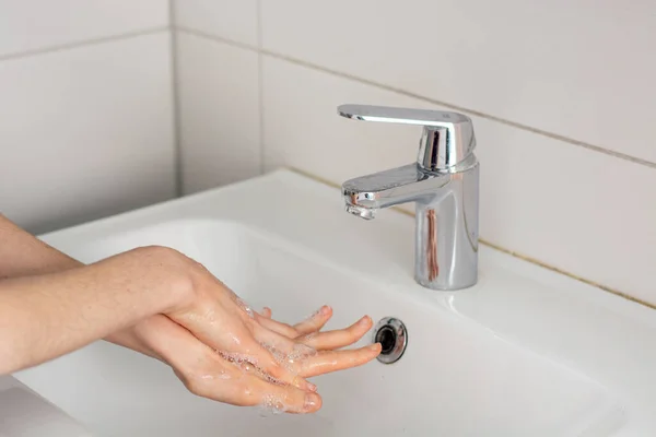 Soaping the hands before washing under tap water close up