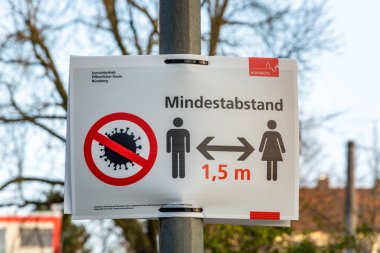 NUERNBERG, GERMANY - 27 Mart 2020: Corona Virüsü nedeniyle en az 1,5 metre mesafeyi korumakla ilgili Almanca imzalayın
