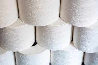 Üst üste yığılmış tuvalet kâğıdı ruloları ön taraftan bir açıyla yakın çekim için.