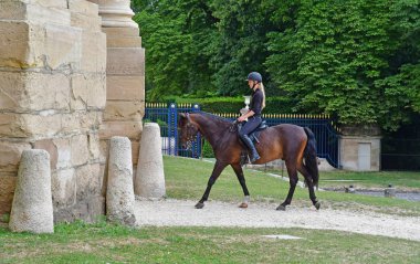 Chantilly, France - august 14 2016 : horsewoman near the castle  clipart