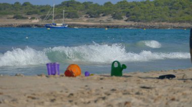Deniz tarafından kum üzerinde oyuncaklar