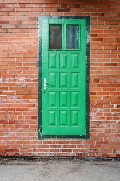 Porta verde su un muro di mattoni rossi — Foto Stock