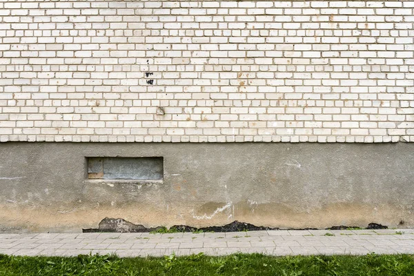 Большой фрагмент стены из белого кирпича с зеленой травой — стоковое фото