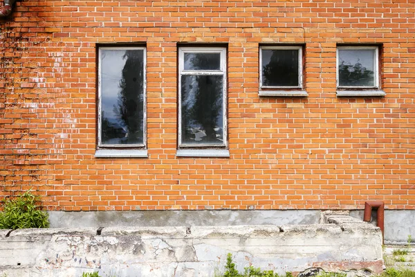 Mur de briques rouges avec quelques fenêtres — Photo