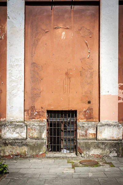 Старая красная стена с двумя колоннами и окном — стоковое фото