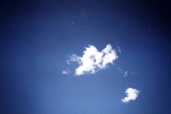 Grunge image of blue sky with a cloud on grainy film texture — Stock Photo, Image