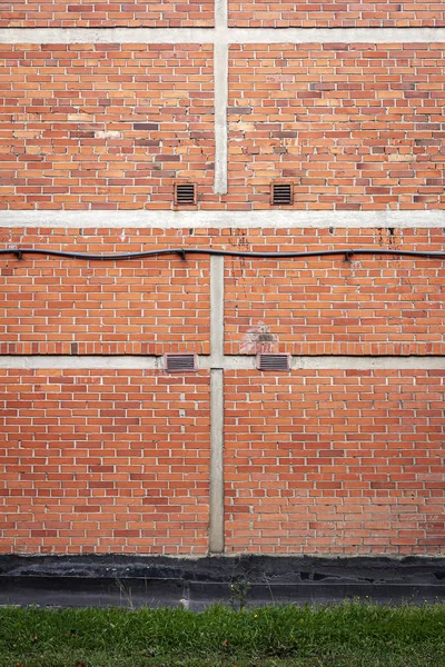 Mattone rosso muro di sfondo con erba verde — Foto Stock