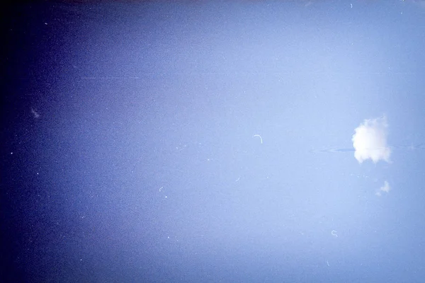 Grunge obraz modré oblohy s mrakem na zrnité fólii textury — Stock fotografie