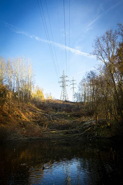 2本の電気パイロンが丘の上の秋に木に囲まれて — ストック写真