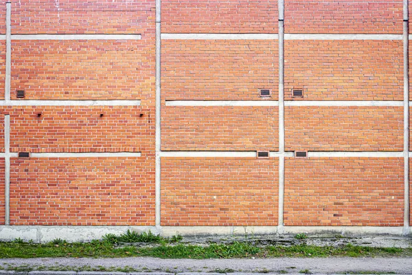 Rött tegel vägg bakgrund med grönt gräs — Stockfoto