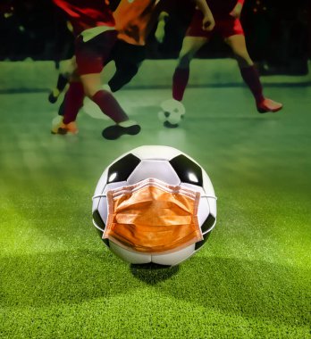 Hava kirliliği ya da salgın nedeniyle maskeli futbol topu. Virüslerden, enfeksiyonlardan, egzoz gazlarından ve endüstriyel emisyonlardan korunma