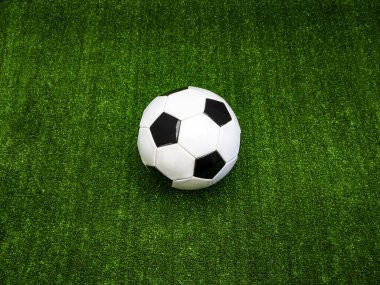 Klasik siyah-beyaz futbol topu yeşil suni çimlerde, tek başına.