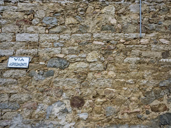 通りの標識を持つサルデーニャの町の典型的かつ古代の石の壁 アスプロモンテ経由 — ストック写真