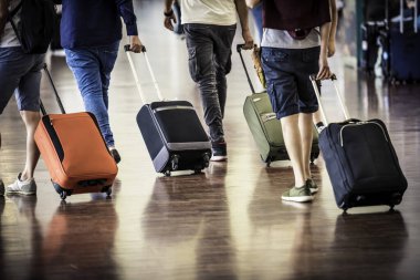 Bavulla havaalanına giden yolcuların bacaklarını kapatın.