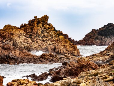 Ogliastra, Sardunya, İtalya 'nın uçsuz bucaksız Akdeniz ovalarında kırmızı porfiri kayaları olan plaj