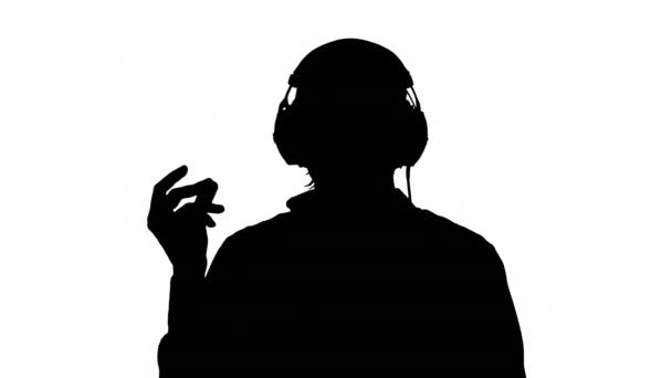 Moving silhouette of a man in headphones listening to the music — Stock Video