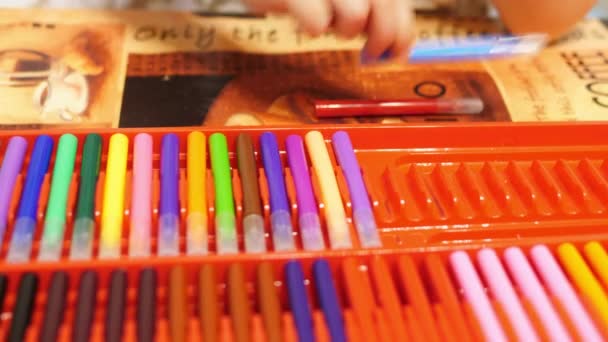 孩子拿出毛毡笔尖笔从一个5岁的孩子 孩子的 Boxclose 特写镜头采取不同颜色的毛毡笔尖笔出一个红色的盒子 并把它们放在桌子上 背景声音 — 图库视频影像
