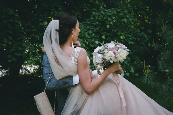 Oblubieniec nosi Panna Młoda w ramionach — Zdjęcie stockowe